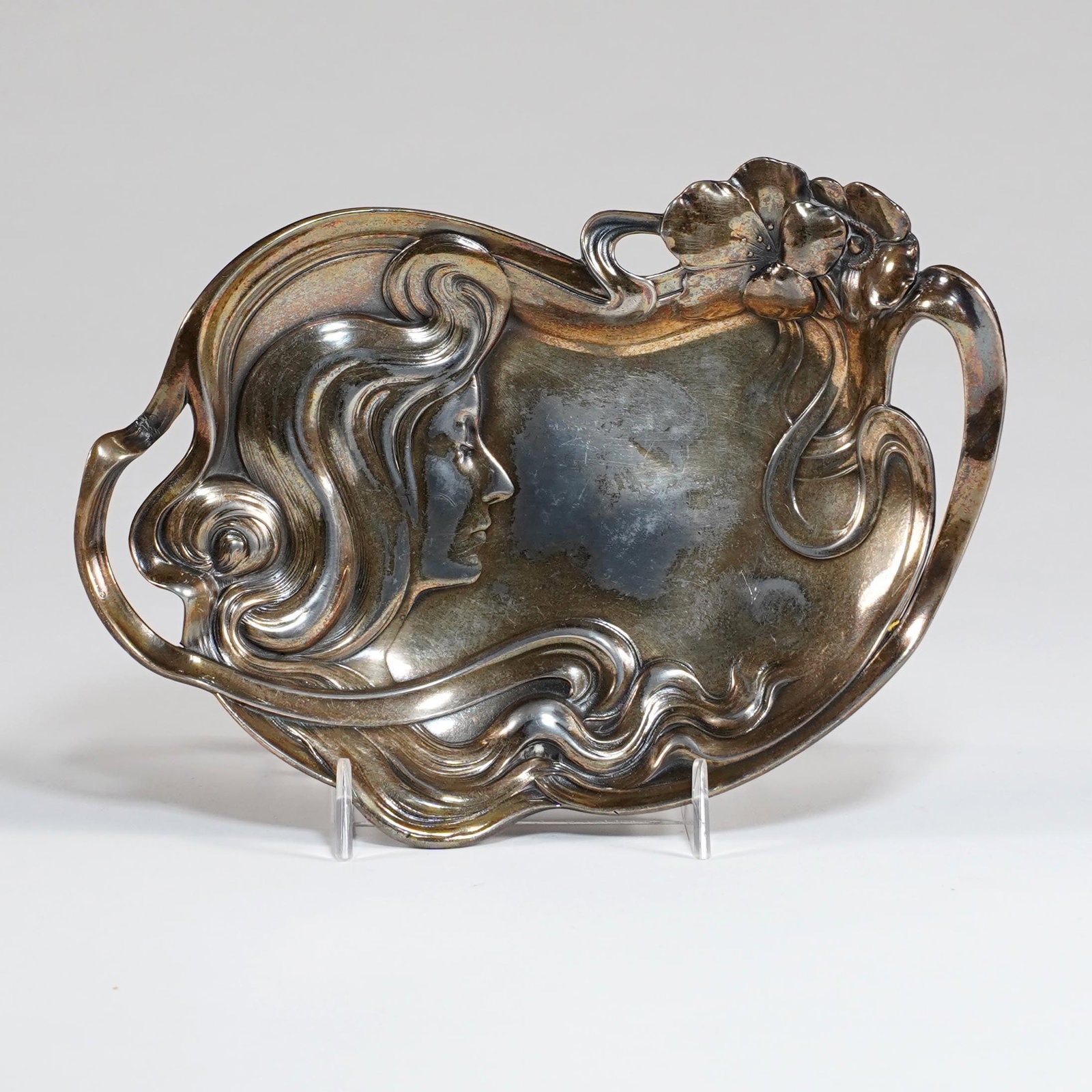 WMF Art Nouveau Silverplate Handled Tray: WMF Art Nouveau silverplate handled tray, Germany, circa 1900–1910, of shaped oval form with open handles, relief decorated with a female profile, flowing hair, flowers, and sinuous whiplash