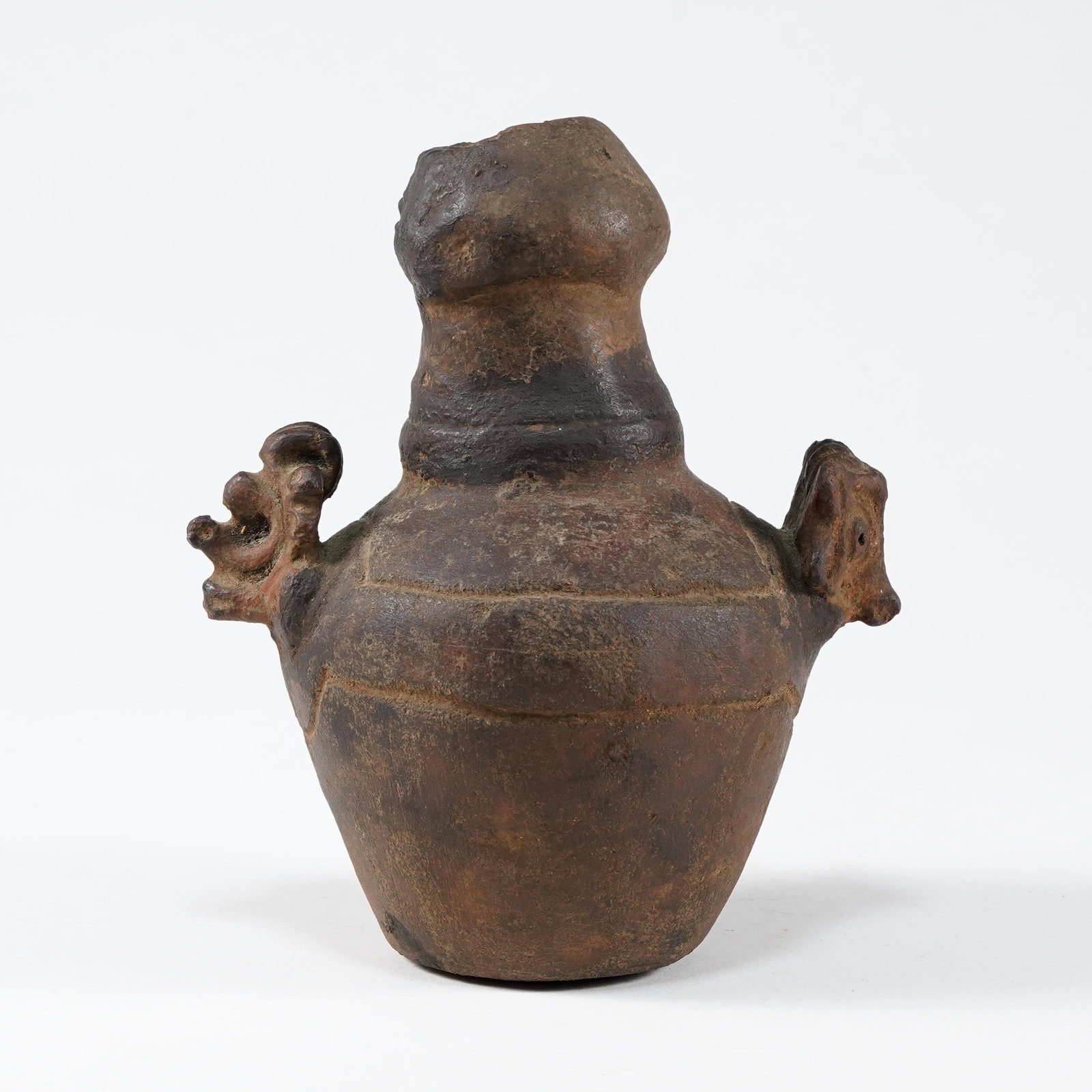 Pre-Columbian Style Pottery Vessel: re-Columbian style earthenware pottery vessel, of globular form with tall neck and applied figural animal-form handles, with dark brown and blackened surface patina. H: 7 1/8 L: 6 x D: 4 1/2 in.