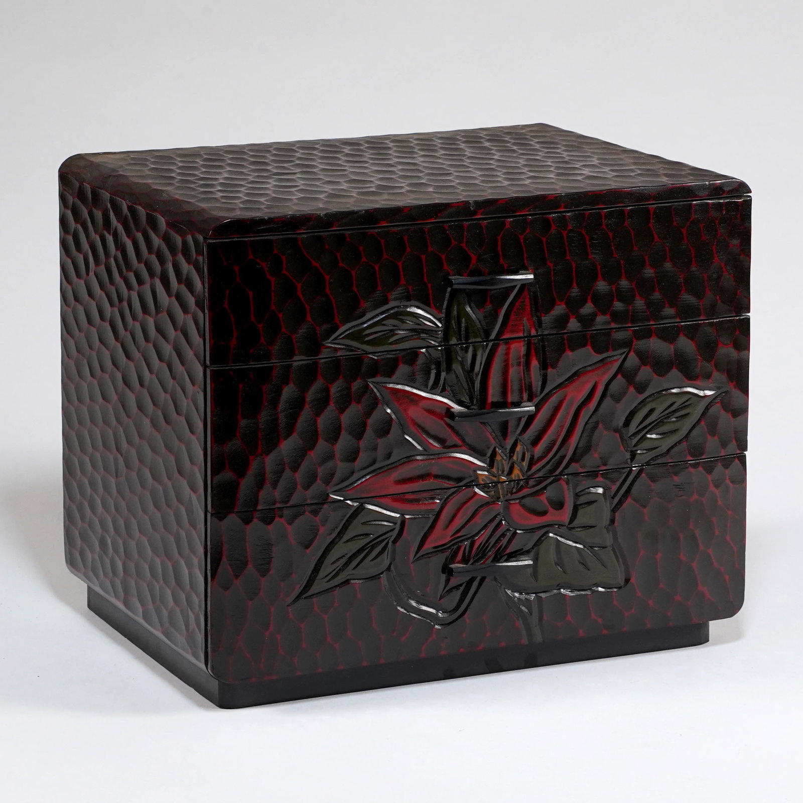 Japanese Lacquered Jewelry / Keepsake Box: Japanese black and red lacquered jewelry box, with three drawers, lift-top compartment, textured crackle-pattern ground, and raised floral decoration. H: 9 3/4 x L: 11 3/4 x W: 8 1/2 in. Property