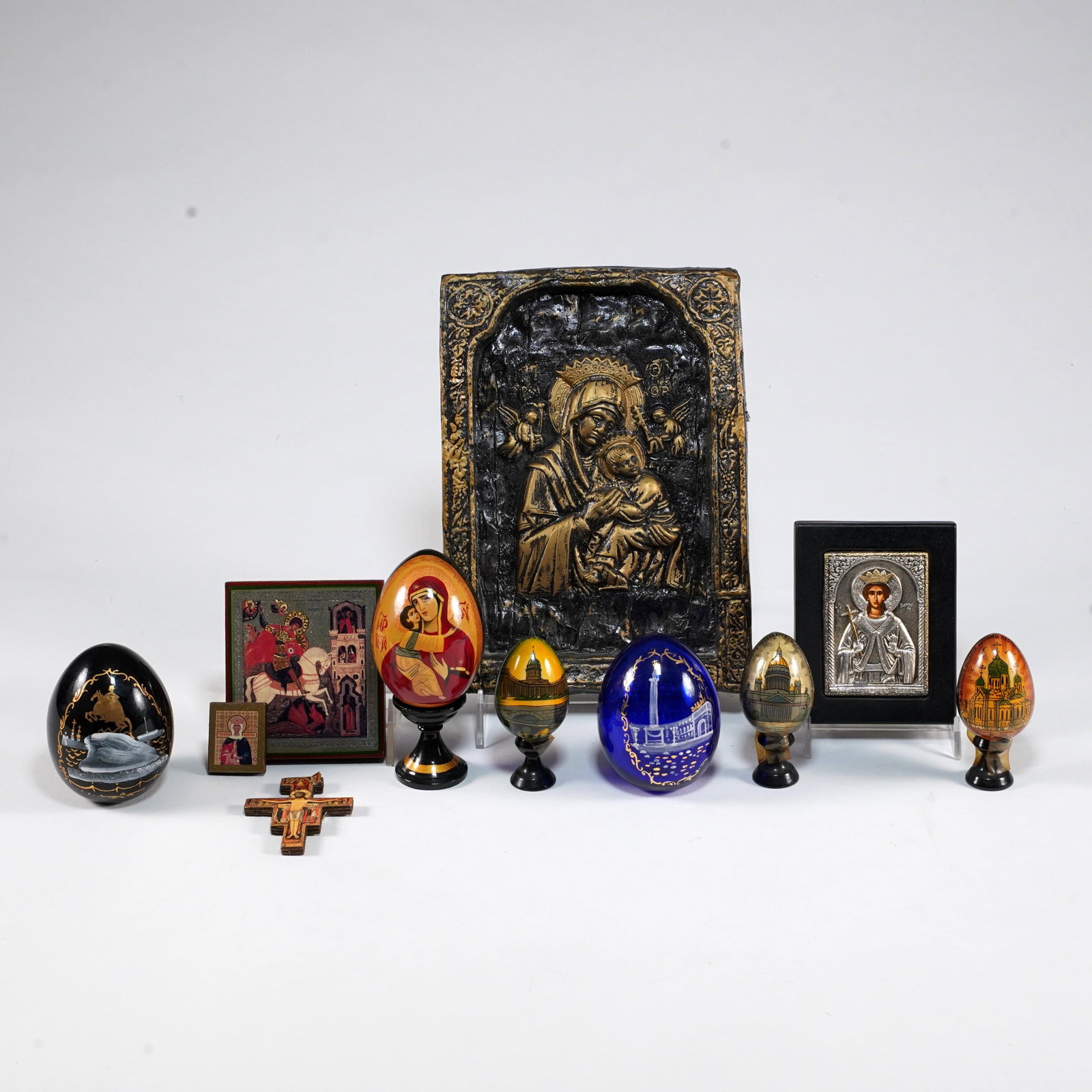 Group of Eastern Orthodox Religious Icons and Decorated Eggs: Group of Eastern Orthodox devotional articles, including relief Madonna and Child icon plaque, miniature painted icons and crosses, and decorated egg-form ornaments with religious and architectural sc