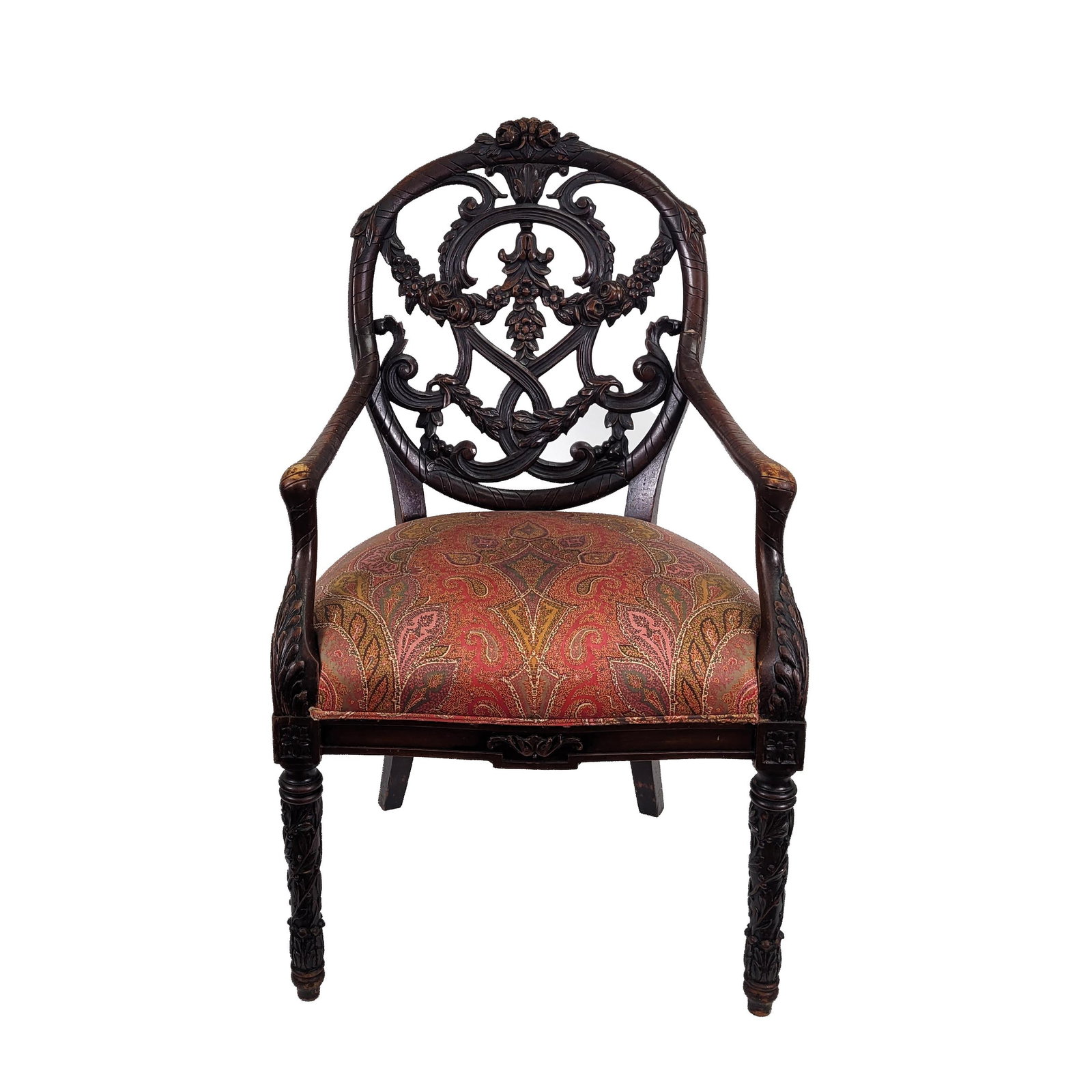 Carved Renaissance Revival Armchair: Carved dark wood Renaissance Revival armchair with pierced circular back, scrolling foliate and floral crest, carved arms, and turned front legs. Upholstered with a red and gold paisley-patterned seat