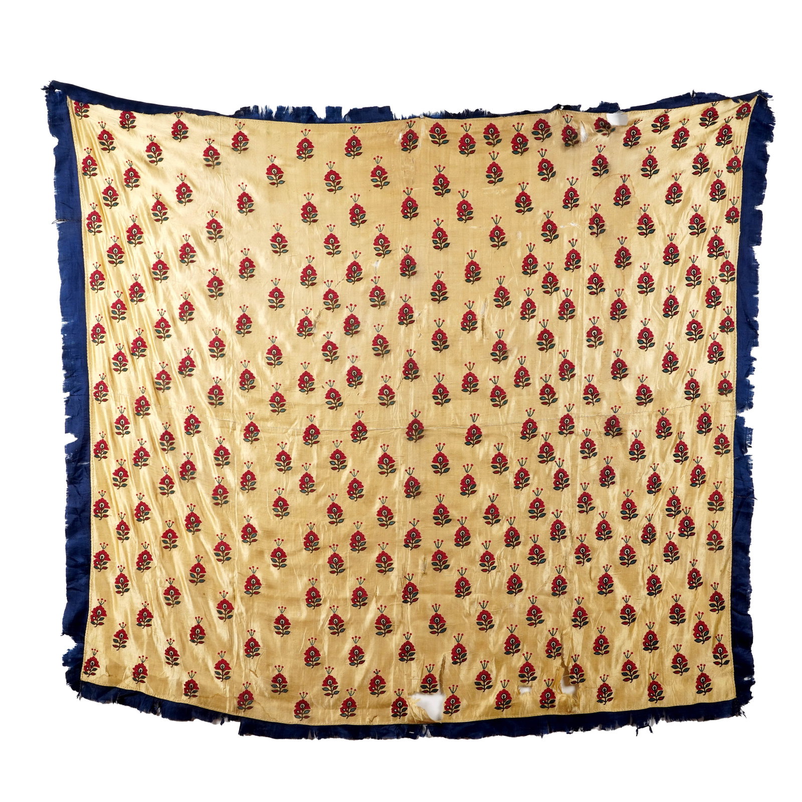 Antique Indian Embroidered Silk Textile: Large golden-ivory silk textile embroidered throughout with repeating stylized red floral buta motifs accented in green and dark blue, the field enclosed by a deep indigo-blue silk fringe. India, 18th
