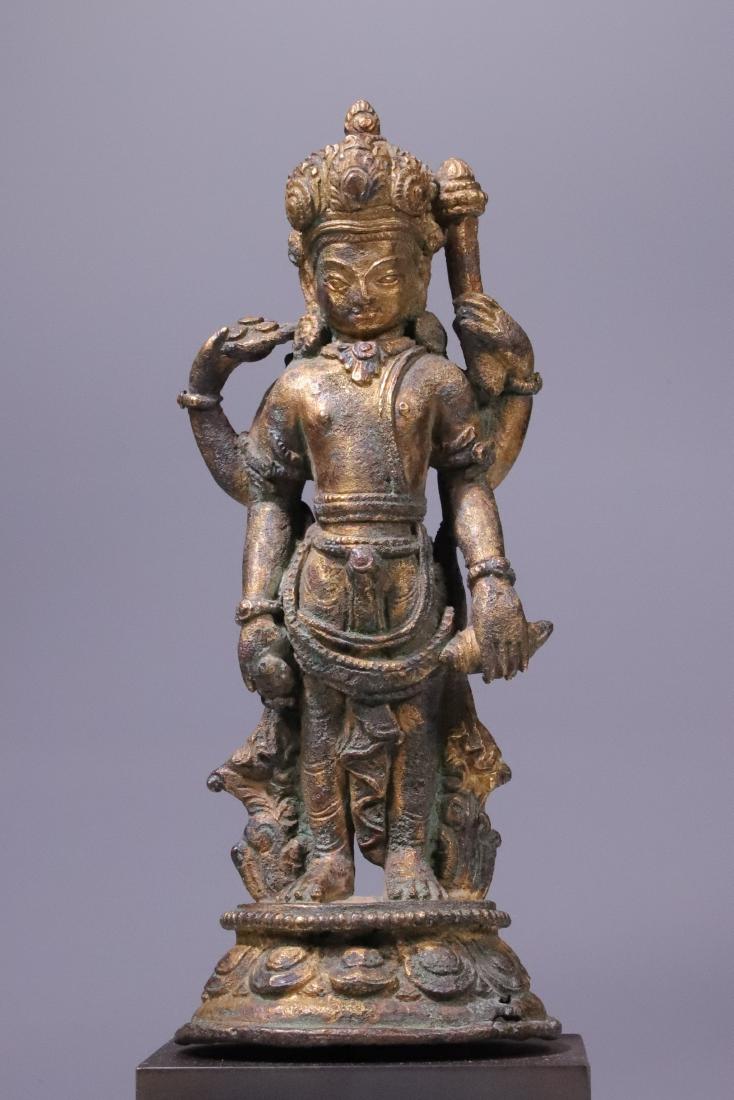 VISHNU: bronze gilt, Nepal , 12th century, Size: 15 cm Four-armed Vishnu holding his attributes, a club called gada, the sudarshana chakra disc-like weapon, a lotus flower and conch shell called shankha. He i