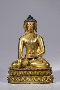 SITTING BUDDHA: bronze firegilt, face gold paintedTibet, 17th centurySize: 17, 5 cmBuddha seated on double lotus base, gesturing the bhumispharsa mudra. The transparent gown is draped over one shoulder, revealing