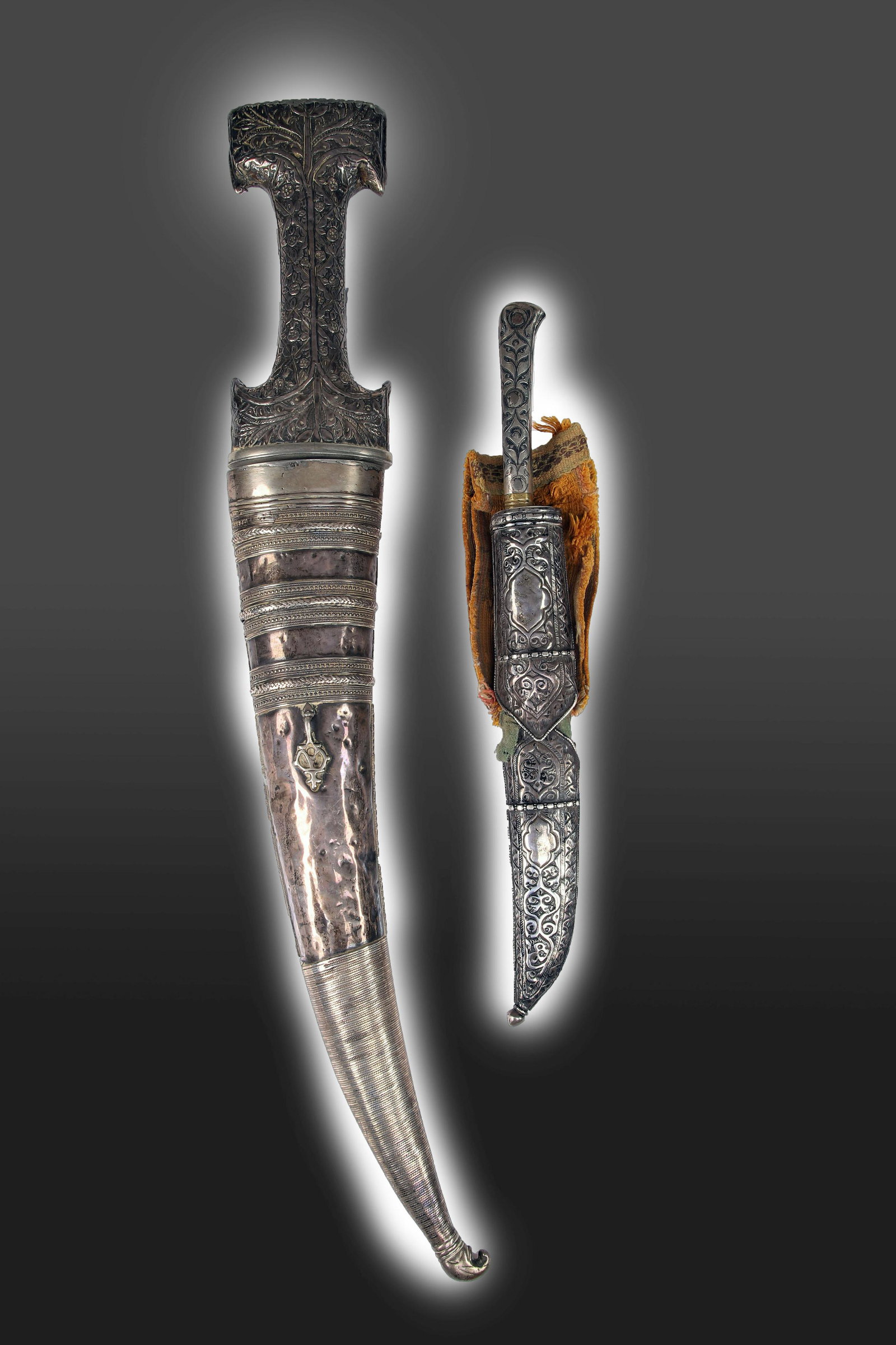 SILVER KNIFE AND SILVER DAGGER: Silver case , Iron bladesIndia , 18th century or laterDimensions: Height 31 cm and 50 cmWeight: 235,9 grams and 989,2 gramsRichly decorated knife and dagger with scabbard. Both are fully covered in or