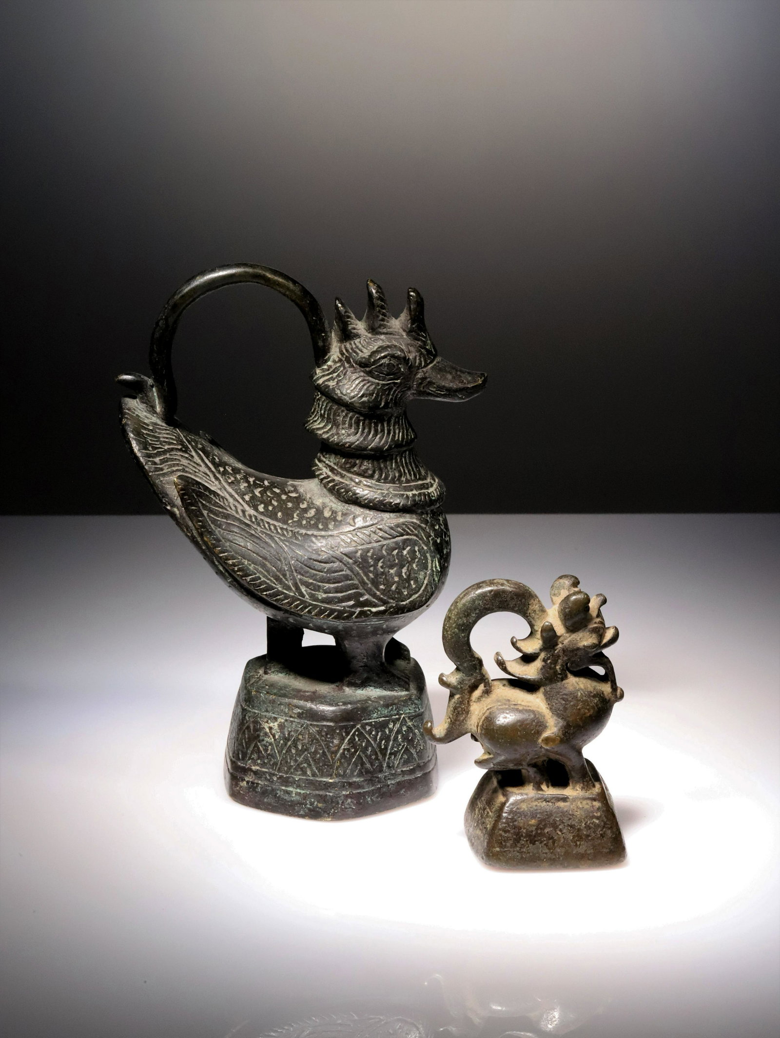 TWO OPIUM WEIGHTS: BronzeLaos and Burma , 19th centuryDimensions: Height 13,5 cm and 7 cmWeights: 1481,8 grams and 320,8 grams Called hintha weights, the weights of the Burmese kingdom usually had the shape of a lion, a