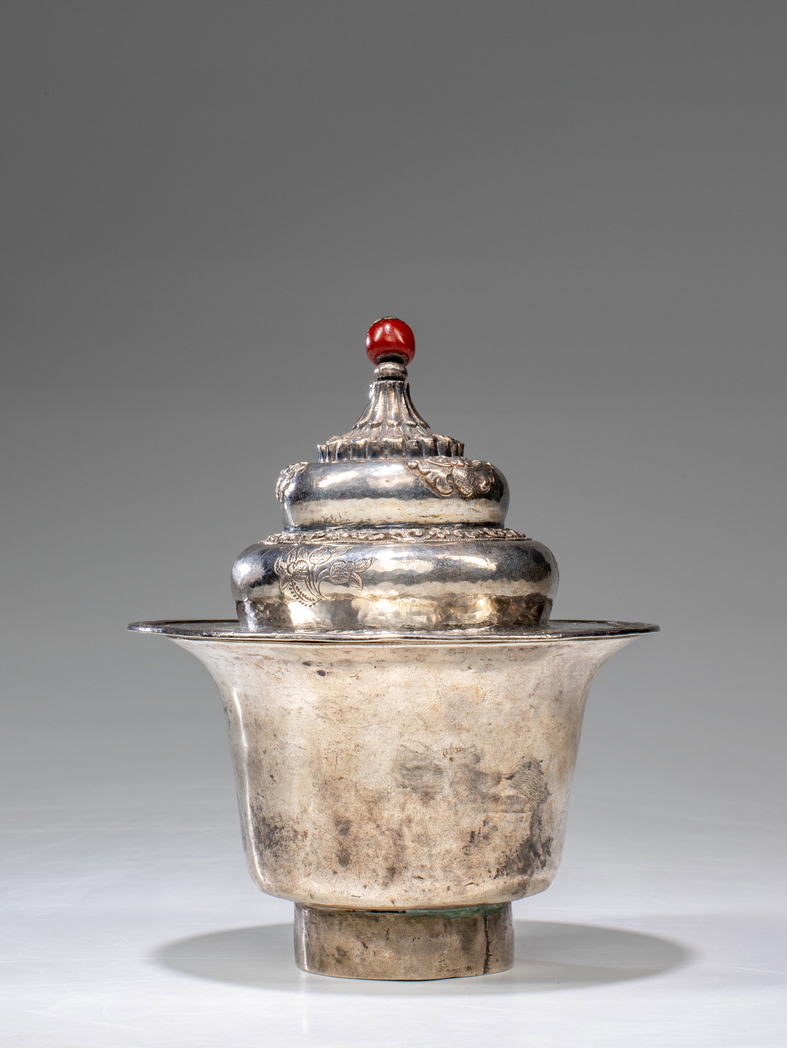 SILVER TEACUP: Dimensions: Height 14 cm Width 11 cm Depth 11 cm Weight: 193 grams The silver teacup and lid with various Tibetan floral motifs and Chinese auspicious signs, teacup consisting of a cup with foot and f
