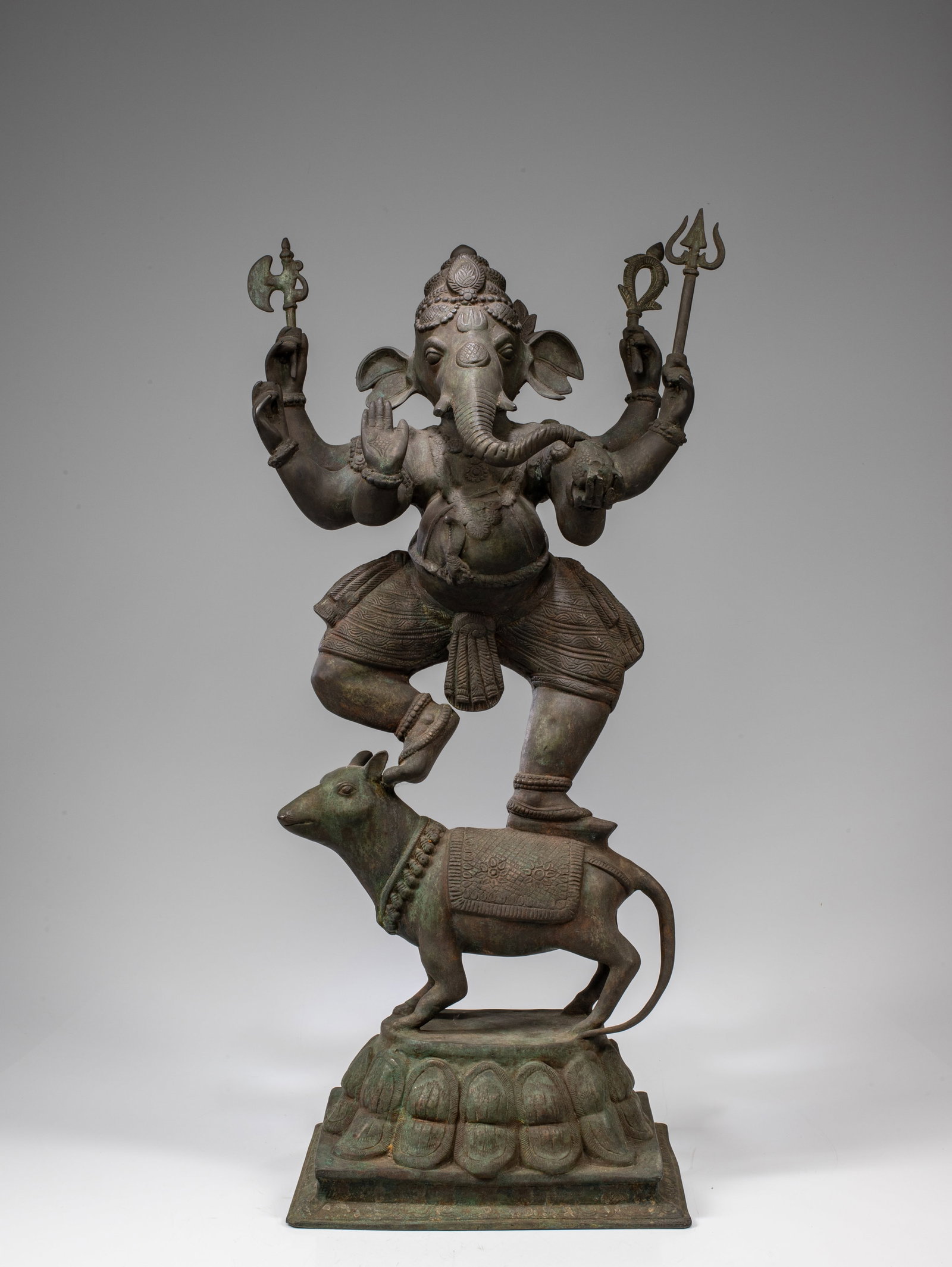 DANCING GANESHA: Bronze India , 18th century Dimensions: Height 90 cm Wide 50 cm Depth 30 cm Weight: 25,6 Kilograms Ganesha's mount, the mouse, is standing on a lotus throne attached to flat surface. The mouse is wear