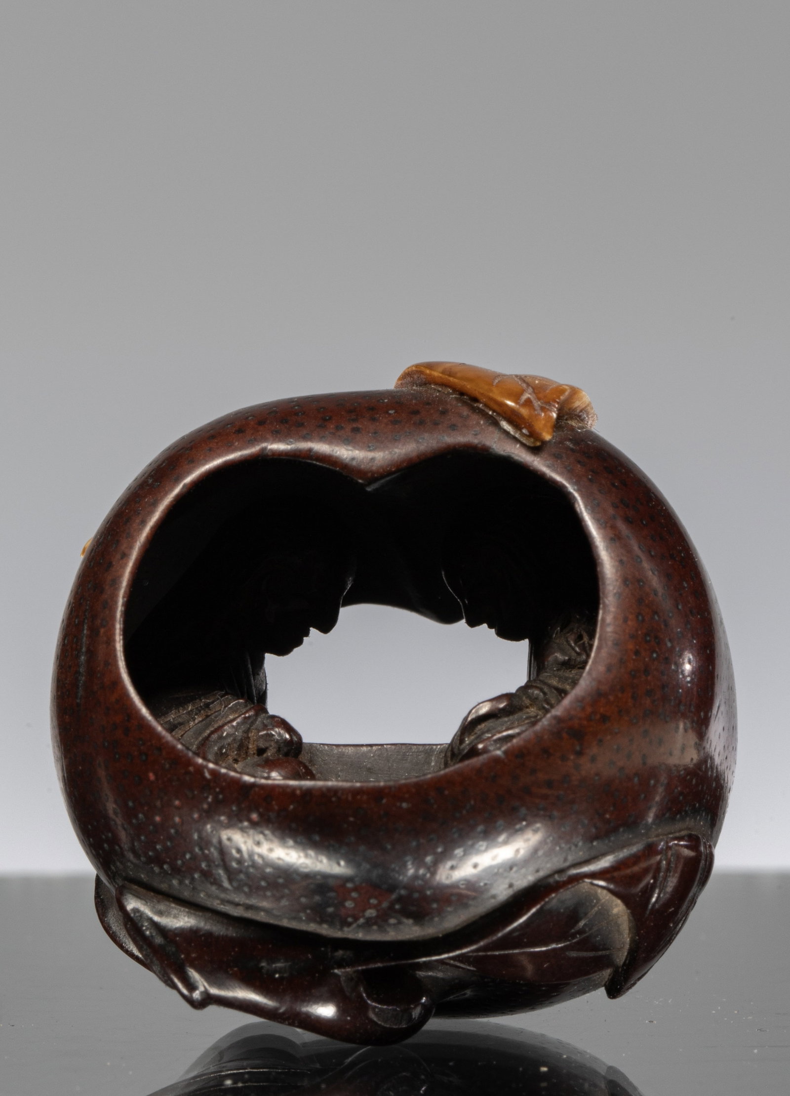 NETSUKE OF A POMEGRANATE WITH INTERIOR CARVING OF A COUPLE: Dimensions: Height 3,4 cm Wide 3,4 cm Depth 3,1 cm Weight: 14 grams highly unusual wooden netsuke carved in the form of a pomegranate fruit, complete with stippling across the surface to simulate its 