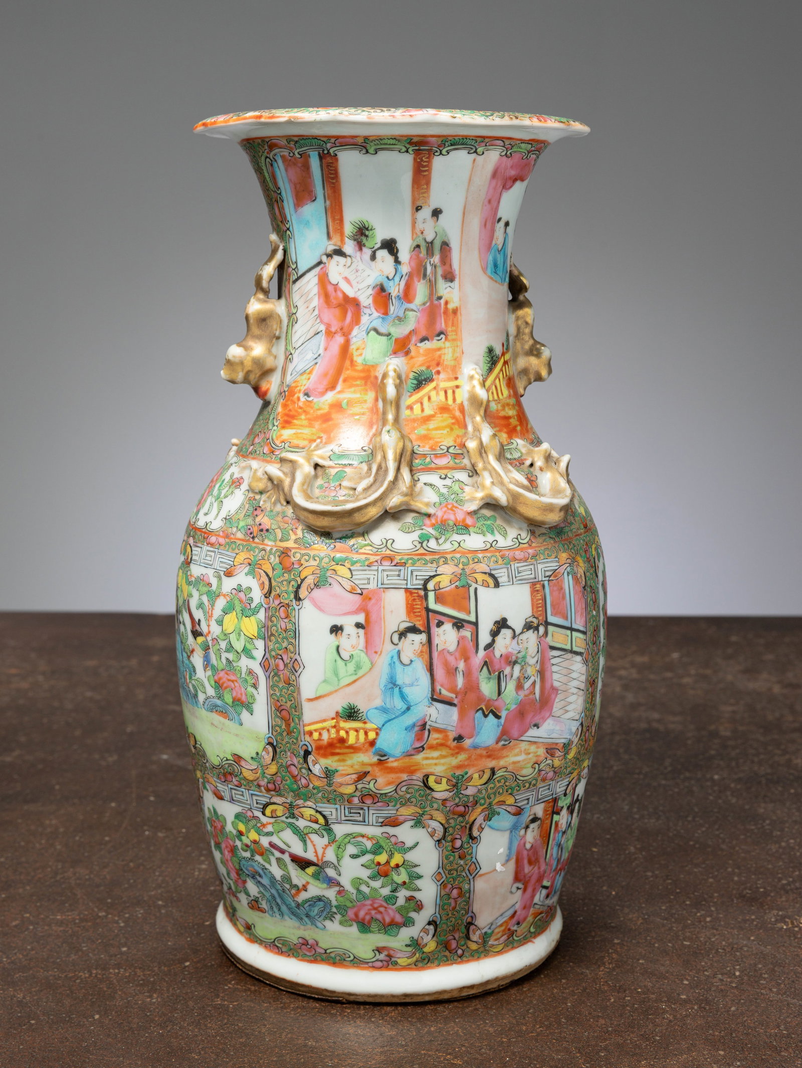 (R) A BULBOUS FAMILLE ROSE VASE WITH GILT RELIEF HANDLES, CHINA , QING DYNASTY 19TH CENTURY: Dimensions: Height 36,5 cm Wide 18 cm Depth 18 cm Weight: 2555 grams Porcelain, richly enamelled in the famille rose palette with vibrant tones of rose, green, turquoise, iron red, and black,