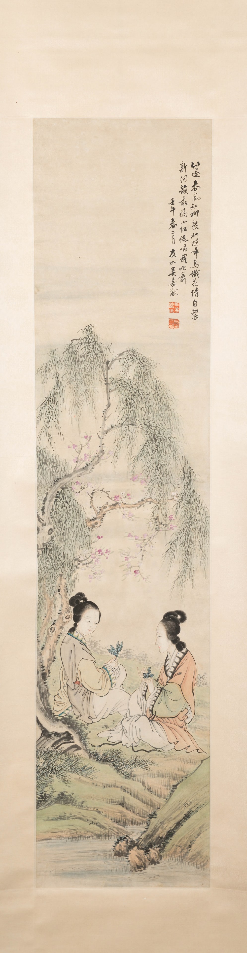 A PAINTING WITH ELEGANT LADIES GATHERED BENEATH WILLOW AND BLOSSOM - WU YOU RU (CIRCA 1840-1893),: Dimensions: 152 cm x 34 cm Ink and light colour on paper, hanging scroll. The composition depicts two refined young women seated beside a stream beneath a gently drooping willow tree, its branches ani
