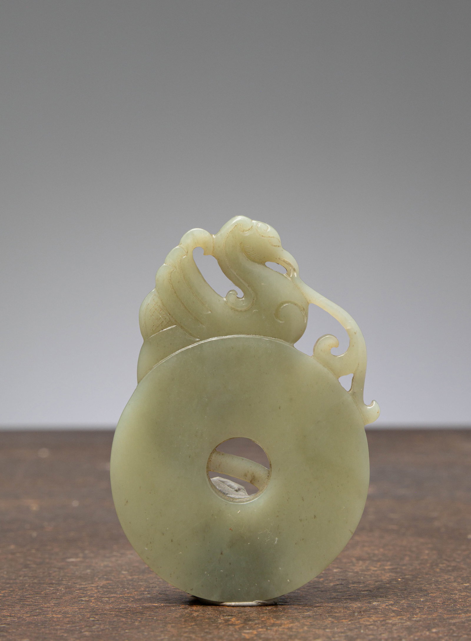 (R) A JADE CELADON BI-DISC WITH PHOENIX, CHINA, 18TH CENTURY (1 of 2)