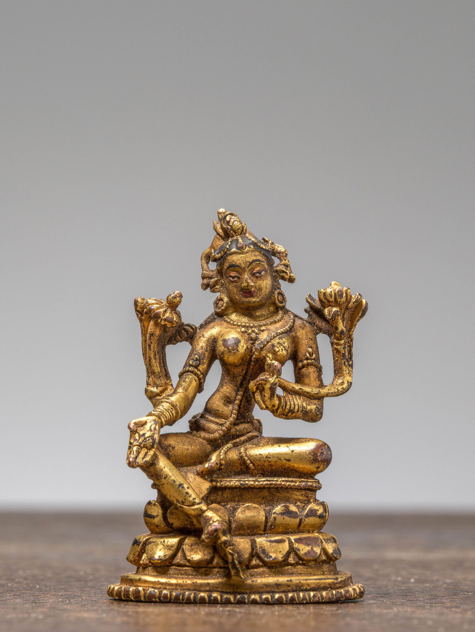 A GILT-BRONZE FIGURE OF GREEN TARA, TIBET, 18TH CENTURY: Dimensions: Height 6,3 cm Wide 4 cm Depth 3,5 cm Weight: 90 grams A finely cast gilt-bronze figure of Green Tara (Shyamatara), seated in