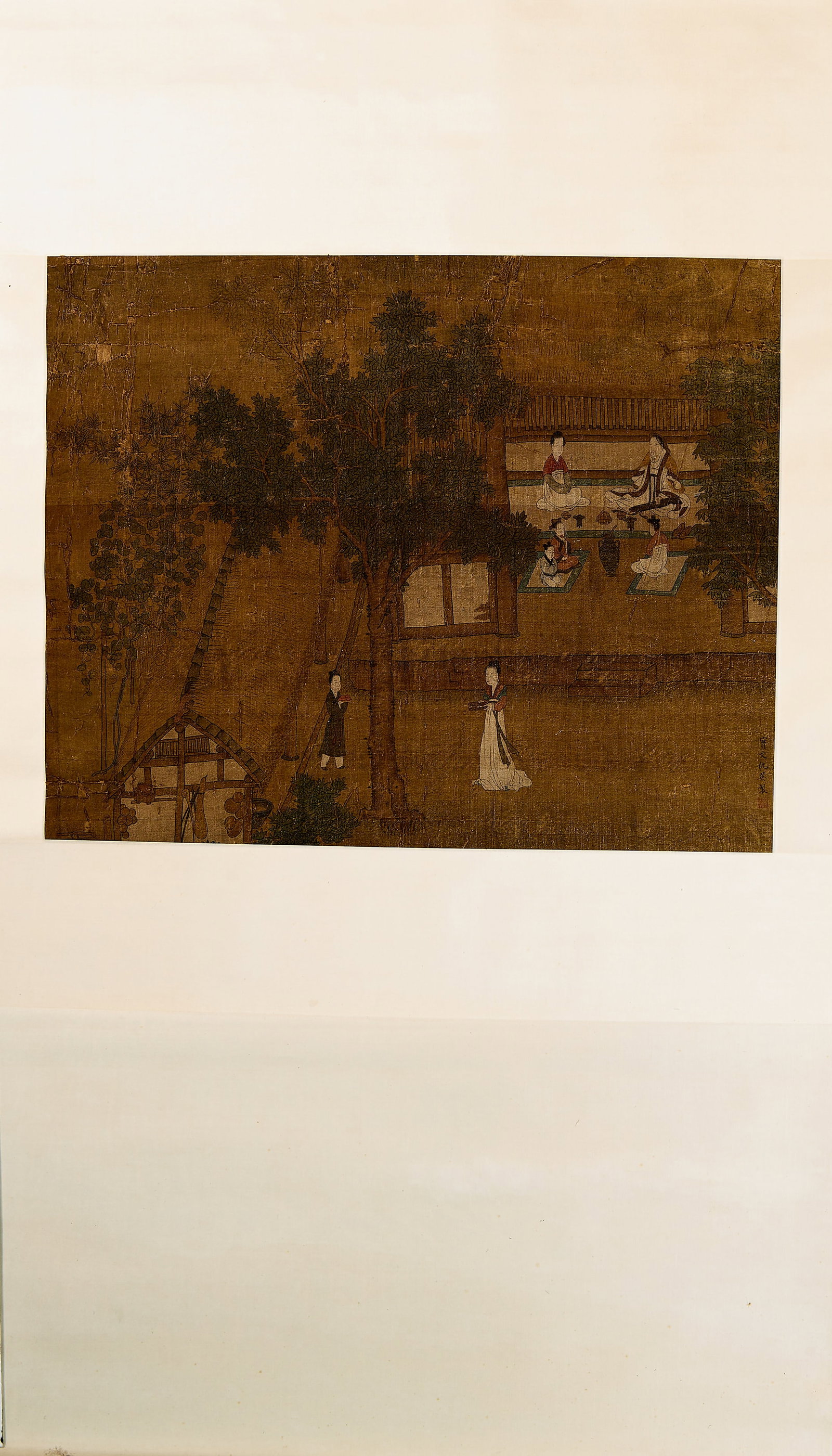 COURTLY GARDEN SCENE , QIU YING (CIRCA 1498-1552): Dimensions: 53 cm x 66 cm Hanging scroll, ink and colour on silk, depicting a gathering of elegant figures within a garden pavilion surrounded by trees and attendants. The composition reflects themes 