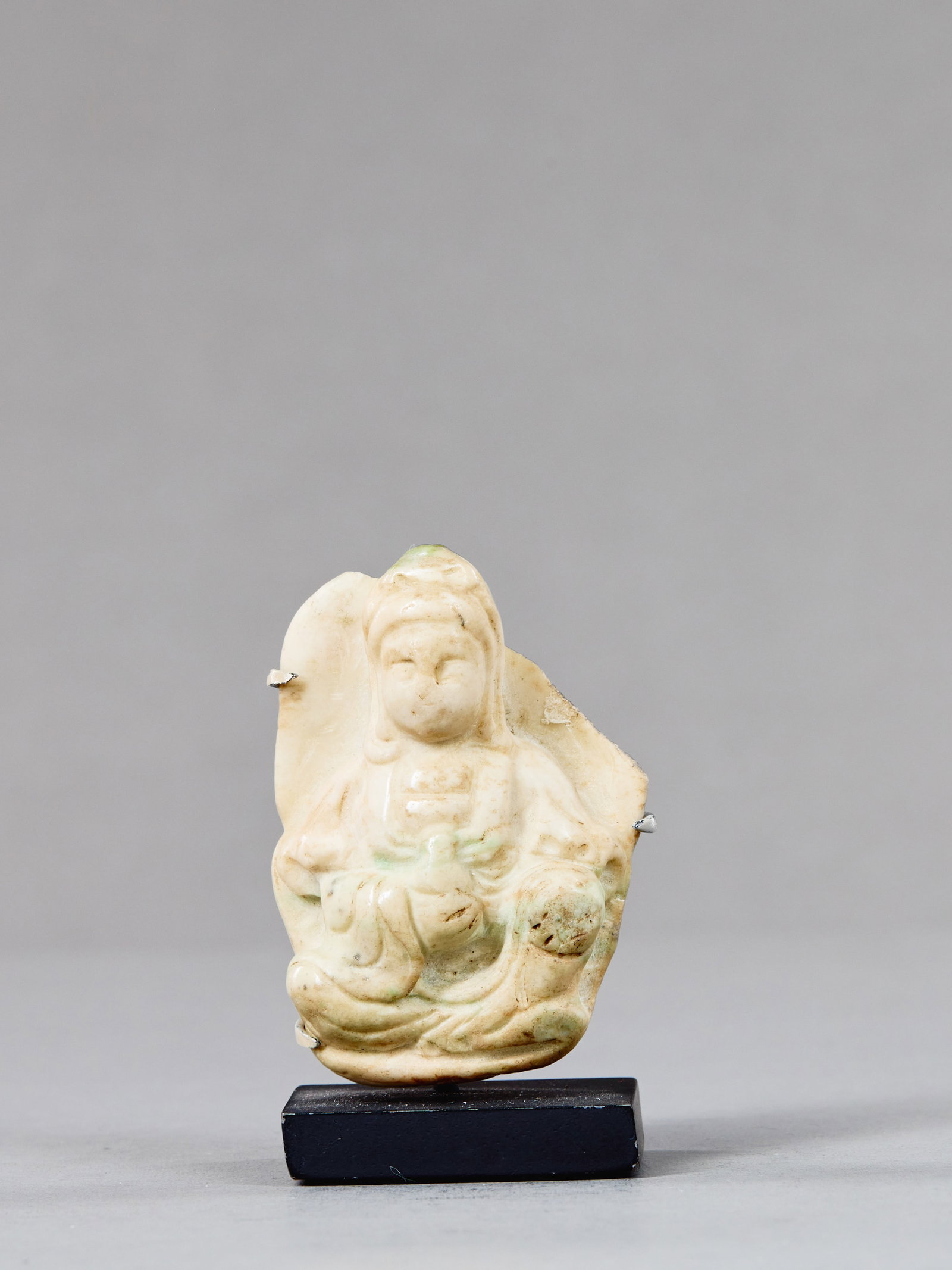 MARBLE GUANYIN CHINA 19TH CENTURY: Dimensions: Height 5 cm Wide 3,5 cm Depth 1,5 cm Weight: 77 grams Carved in pale white marble with subtle traces of natural green inclusions, the figure depicts Guanyin, the Bodhisattva of Comp