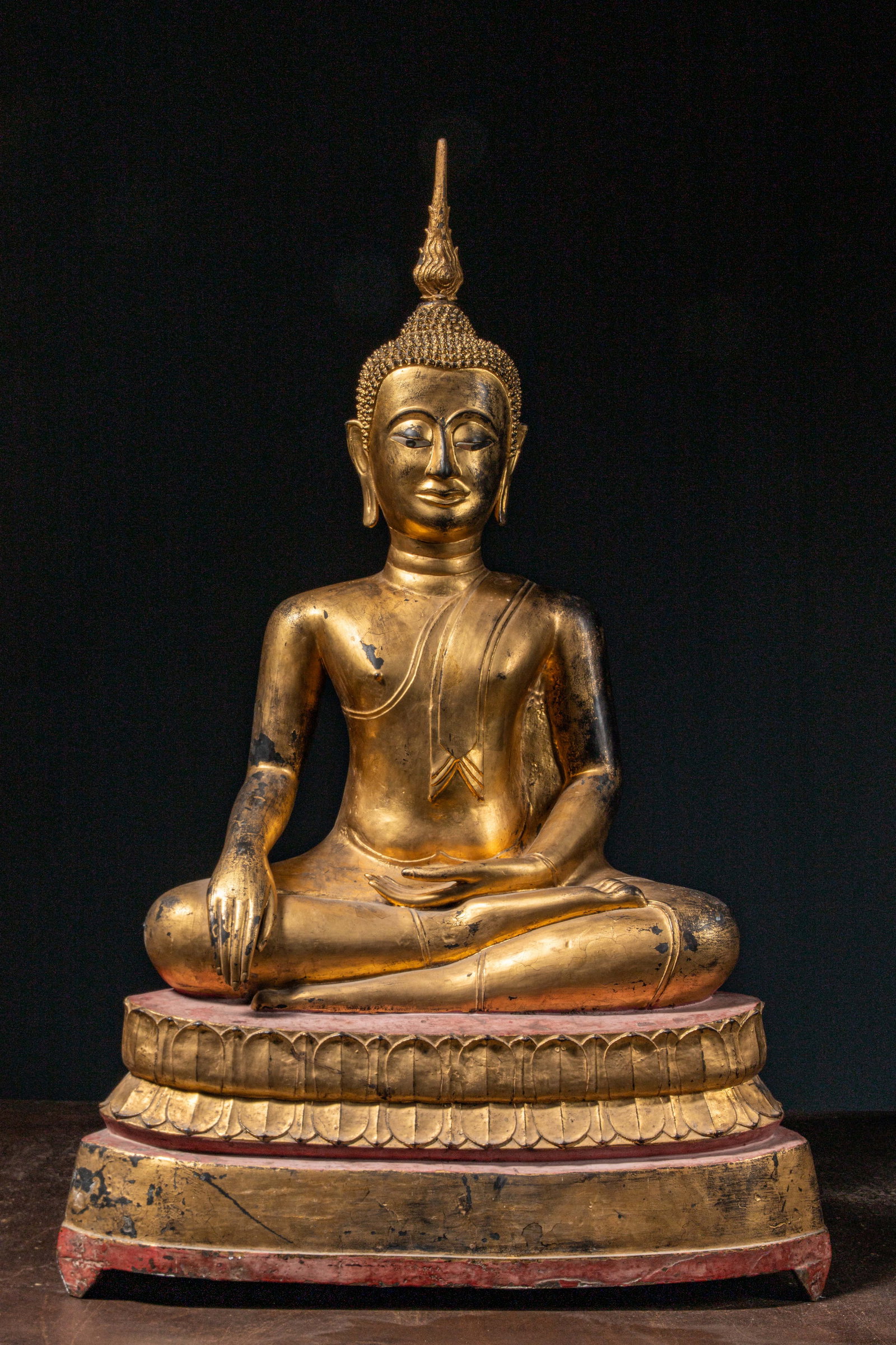 (R) A SEATED COLD GILT BRONZE BUDDHA, THAILAND, 19TH CENTURY: Dimensions: Height 108 cm Wide 69 cm Depth 42 cm Weight: 80,8 Kilograms The Buddha is seated in vajr?sana (lotus posture) on a high double lotus pedestal