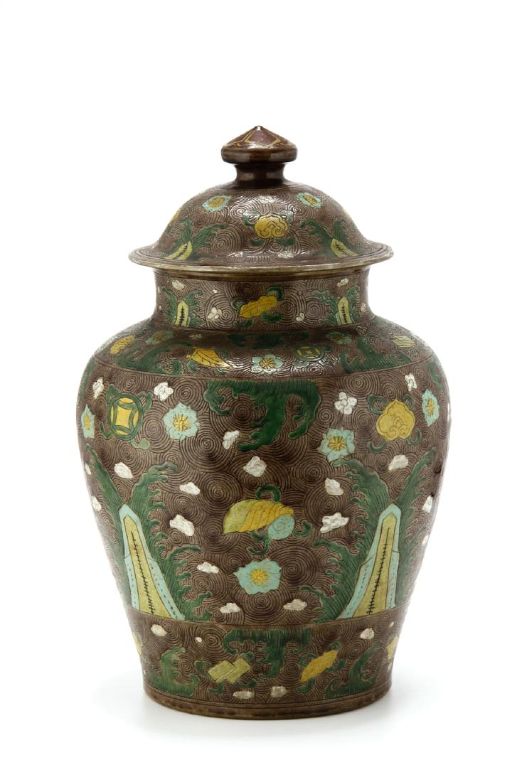 Large Famille Verte Jar and Cover: Of stoutly potted baluster form, painted in bright enamels with flowers and auspicious objects amidst waves crashing against mountain peaks, all reserved on? spiral-covered brown ground, the domed cov