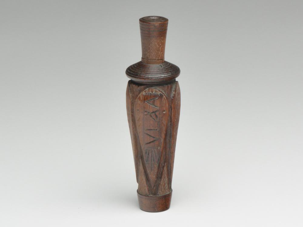 Carved duck call, Charles Perdew, Henry, Illinois.: Carved duck call, Charles Perdew, Henry, Illinois. St. Francis or VL&A style. With four raised checkered panels, "VL&A" carved in one of them. 6". Provenance: Brian Stead collection.