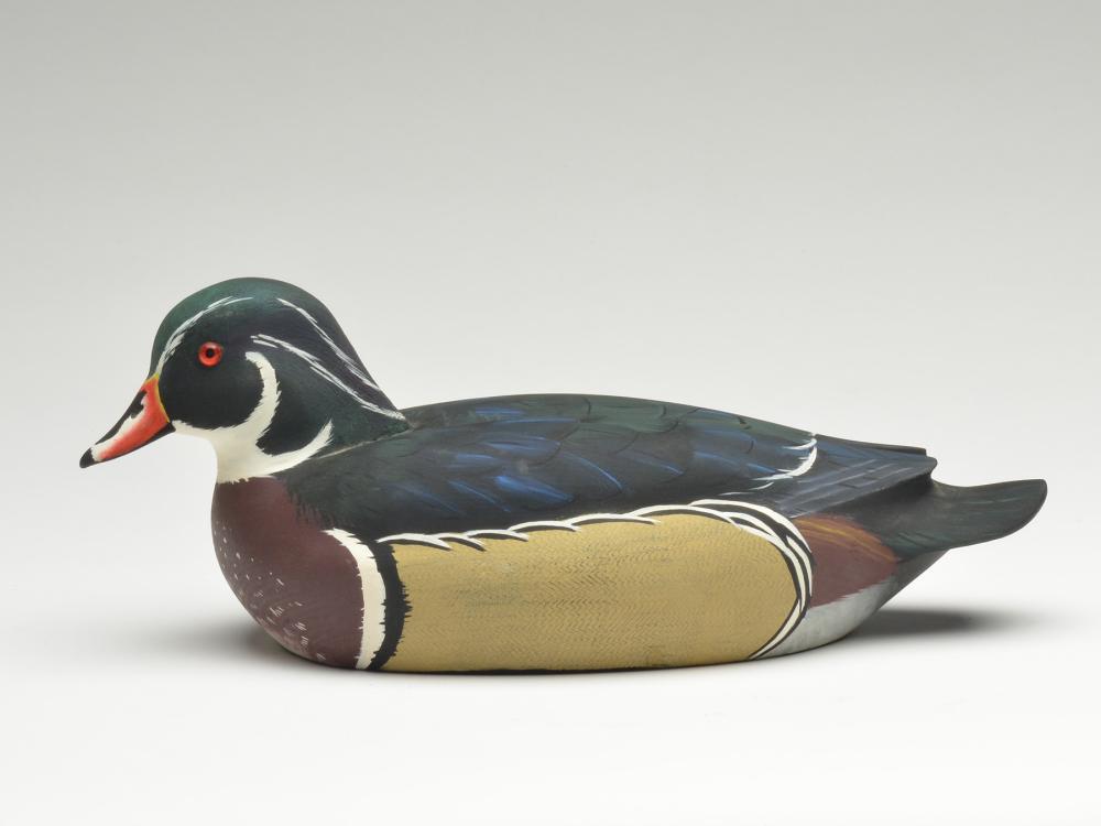 Wood duck drake, Pat Meneely, Minneapolis, Minnesota.: Wood duck drake, Pat Meneely, Minneapolis, Minnesota. Signed on underside. Head is slightly turned. Carved crest and tucked head. Raised wingtips. Combing on sides. 14" long. Literature: "Decoys, 60 L
