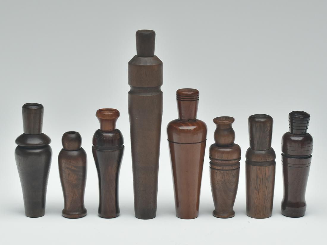 Eight duck calls.: Eight duck calls. All appear to show honest age and are by different makers. Longest call is marked "JF" at tip of stopper. Shorter call with lay marks resemble Skippy Barto. Lighter colored wood call