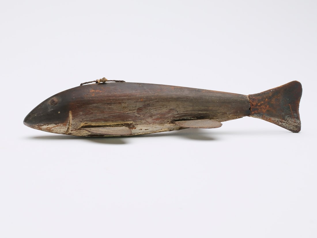 Unknown maker (last quarter 19th century), Lake Chautauqua, New York.: Early fish spearing decoy. Carved gill and tack eyes, metal fins, and classic leather tail. Mearures 7" long. Literature: "Beneath the Ice," Steven Michaan, p. 58, exact fish pictured.