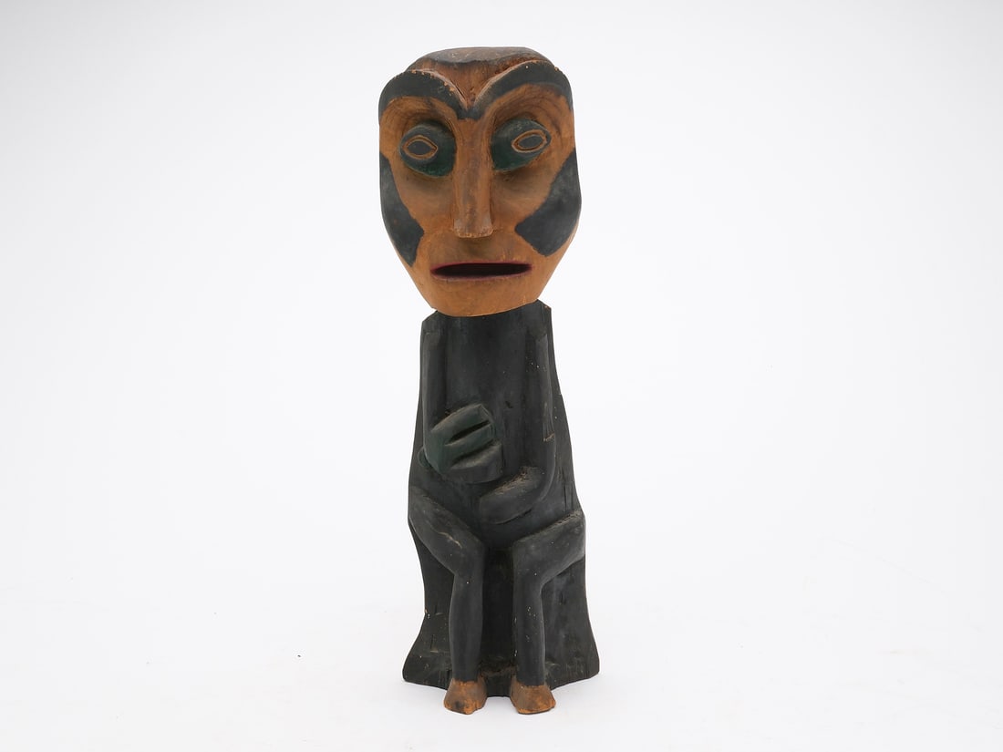 Early tourist totem from Wrangell, Alaska.: Of a seated man. Deep relief carved features. Stands 14" tall.