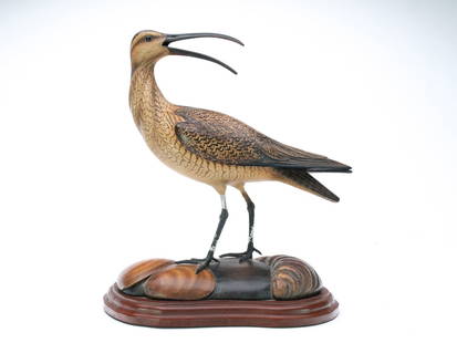 William Gibian (b.1946), Onancock, Virginia.: Decorative standing curlew with turned head and open beak. Deep relief wing carving with raised, crossed wingtips. Base with carved clam and oyster shells. Maker's business card on underside is signed