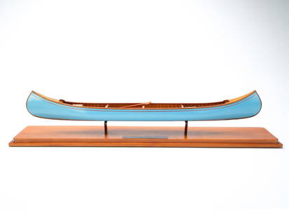 Christopher Pearson.: Beautifully handcrafted canoe model. With woven seats and two paddles carved to scale. Metal plaque on top of base is signed and numbered 8. Canoe measures 27" long. Provenance: Tom Karras collection.