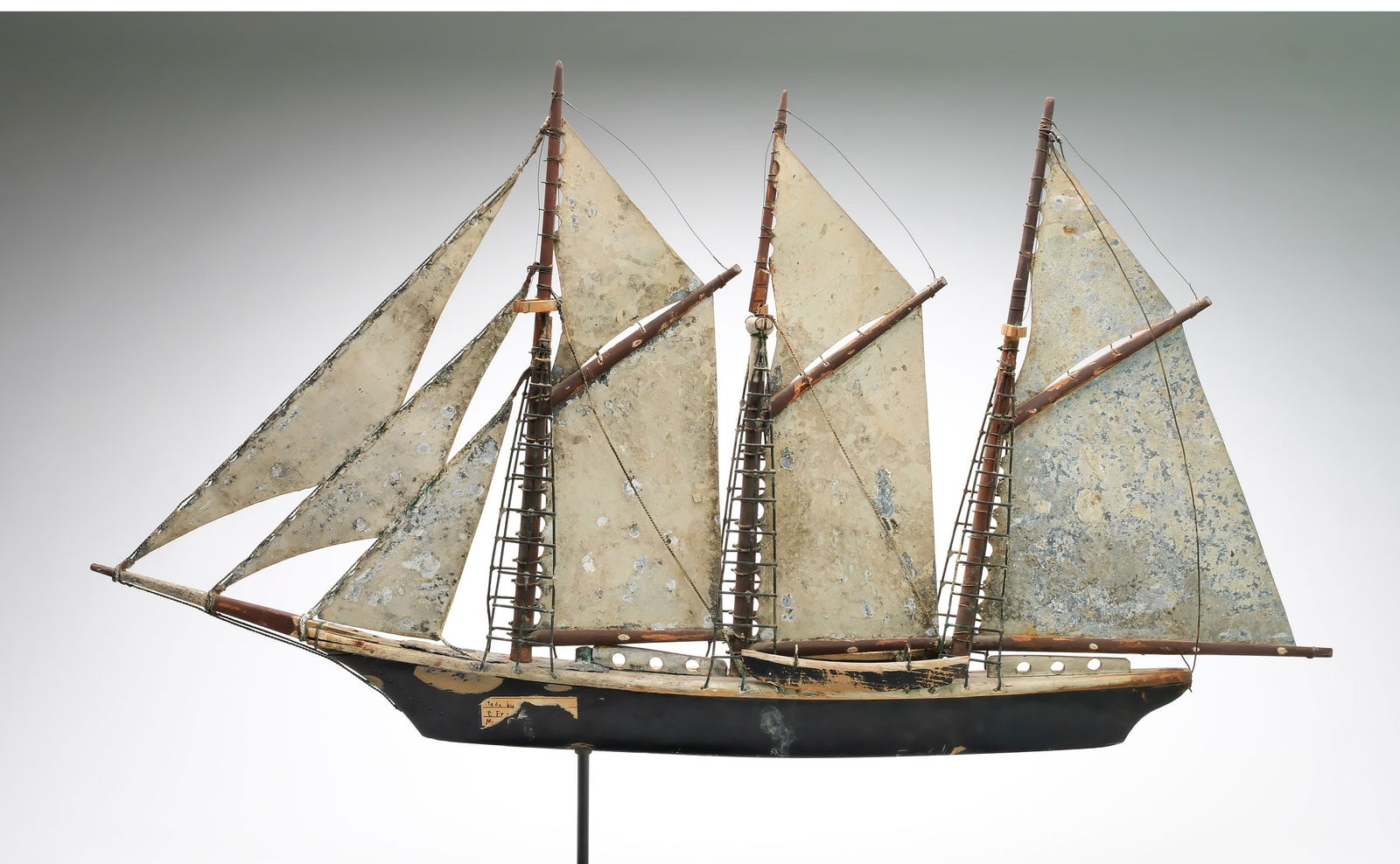 Early vintage weathervane.: Sailing vessel with nine sails. Made by Frank Adams, Massachusetts. Sheet metal sails. Boat made from wood and polychrome paint. Measures 39" long x 21" tall. Provenance: Martin and Deborah Maloy coll