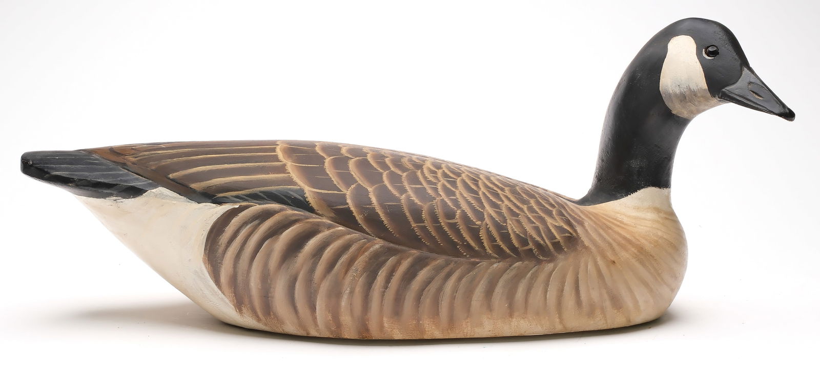 Ward Brothers, Crisfield, Maryland.: Canada goose. Hollow carved shooting stool model with slightly turned head and relief wing carving. Signed and dated 1970 on underside. Measures 22.5" long. Excellent and original.