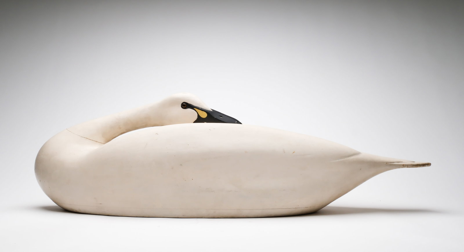 Charles E. "Shang" Wheeler (1872-1949), Stratford, Connecticut.: Exceedingly rare sleeping swan. Hollow carved with relief wing feather carving. Swan was rigged and weighted with a wooden keel having been removed. One of two known. Measures 38" long. Provenance: Es