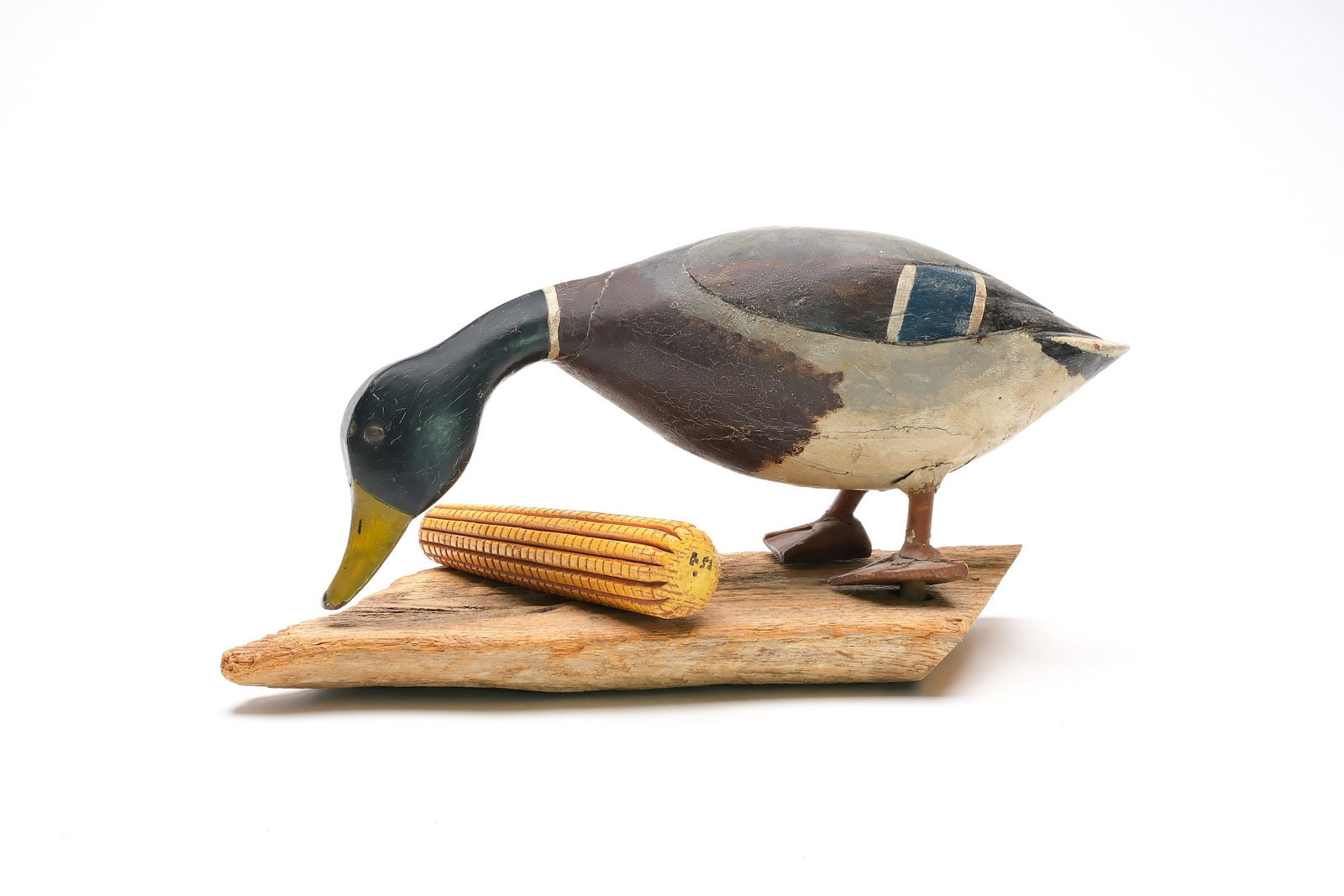 Jack Stiles.: Rare feeding field mallard. Balsa body with relief wing carving and tack eyes. Decoy was made for use on land, with a carved wooden corn cobb included. Measures 17.5" long. Provenance: Jim and Diane C