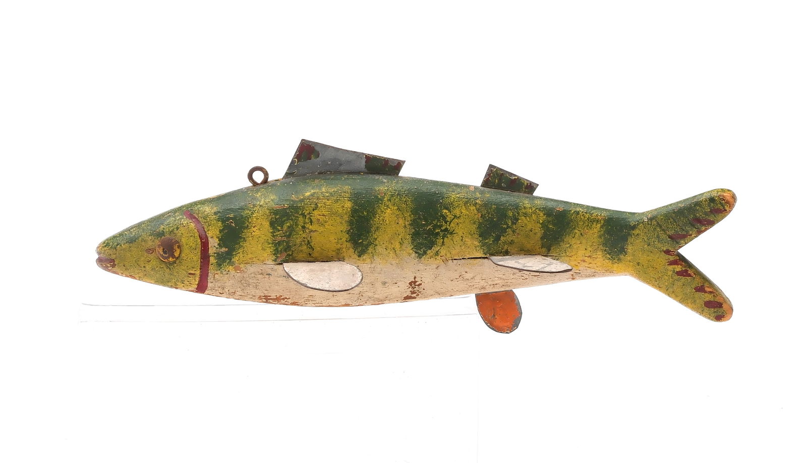 Pecor Fox, Mt. Clemens Michigan, 1st half 20th century.: Perch fish decoy with seven metal fins. Tack eyes and carved mouth and gills. Tail fin is also slightly carved. Measures 8" long. Provenance: Private Michigan collection.