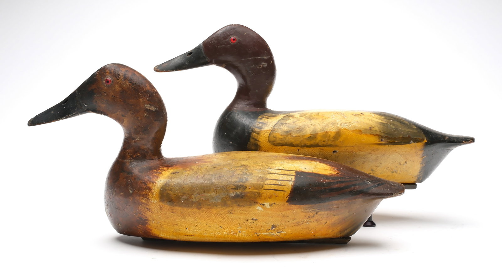 Bert Graves (1880-1956), Peoria, Illinois.: Pair of canvasbacks. Hollow carved with comb feather paint detail. Retains the maker's original weights. Measure 16.75" long. Provenance: Dr. Michael Shannahan collection.