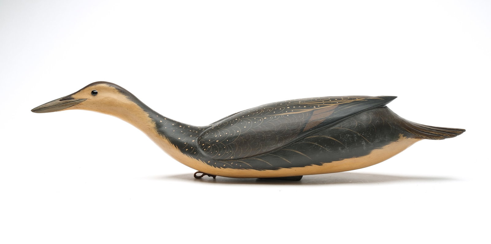 Bob White (b. 1939) Tullytown, Pennsylvania.: Rare swimming juvenile arctic loon. Hollow carved with deep relief wing carving and raised wingtips. Head is slightly turned. Signed and dated 1988. Measures 26" long.