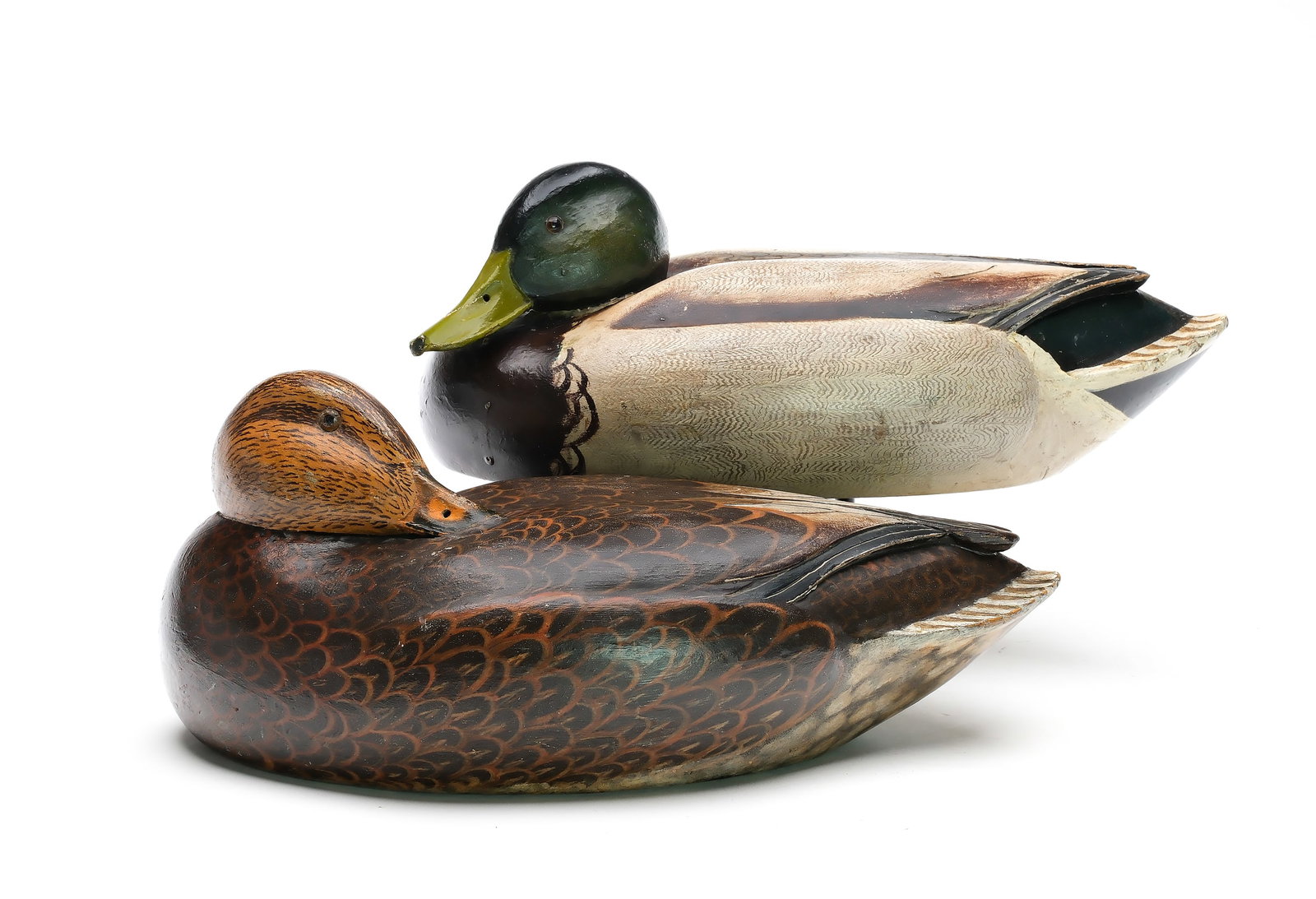 Ferd Homme (1901-1963) Stoughton, Wisconsin.: Rigmate pair of mallards. Hollow carved with raised wingtips and relief tail feather carving. Drake’s head is tucked and slightly turned. Hen in sleeping pose. Maker’s name painted on unde