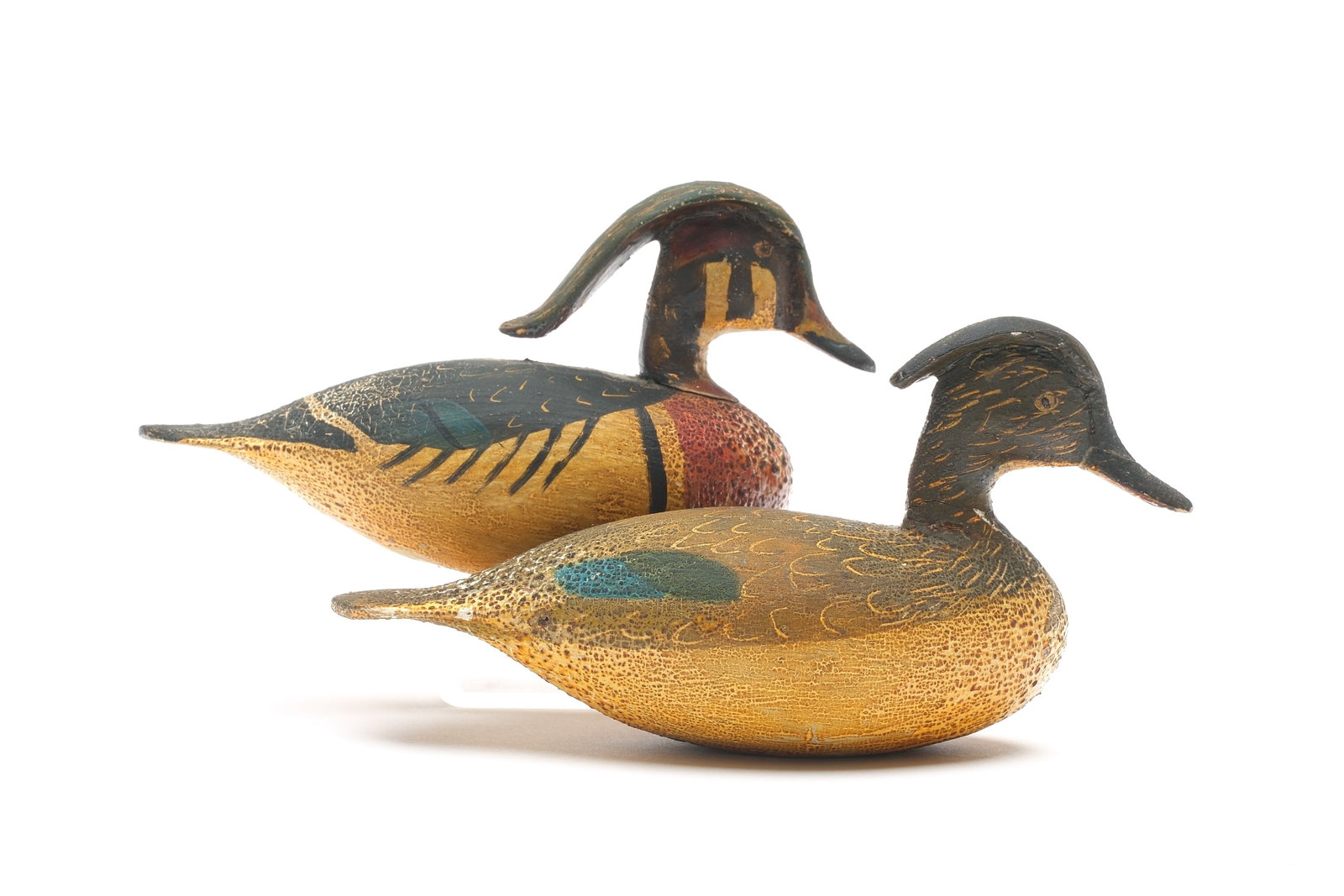 Ira Hudson (1873-1949), Chincoteague, Virginia.: Very rare pair of miniature wood ducks. Drake with exaggerated, extended crest. "MAS" in pencil on undersides. Measure 5.25" long. Provenance: Oliver Smith collection.