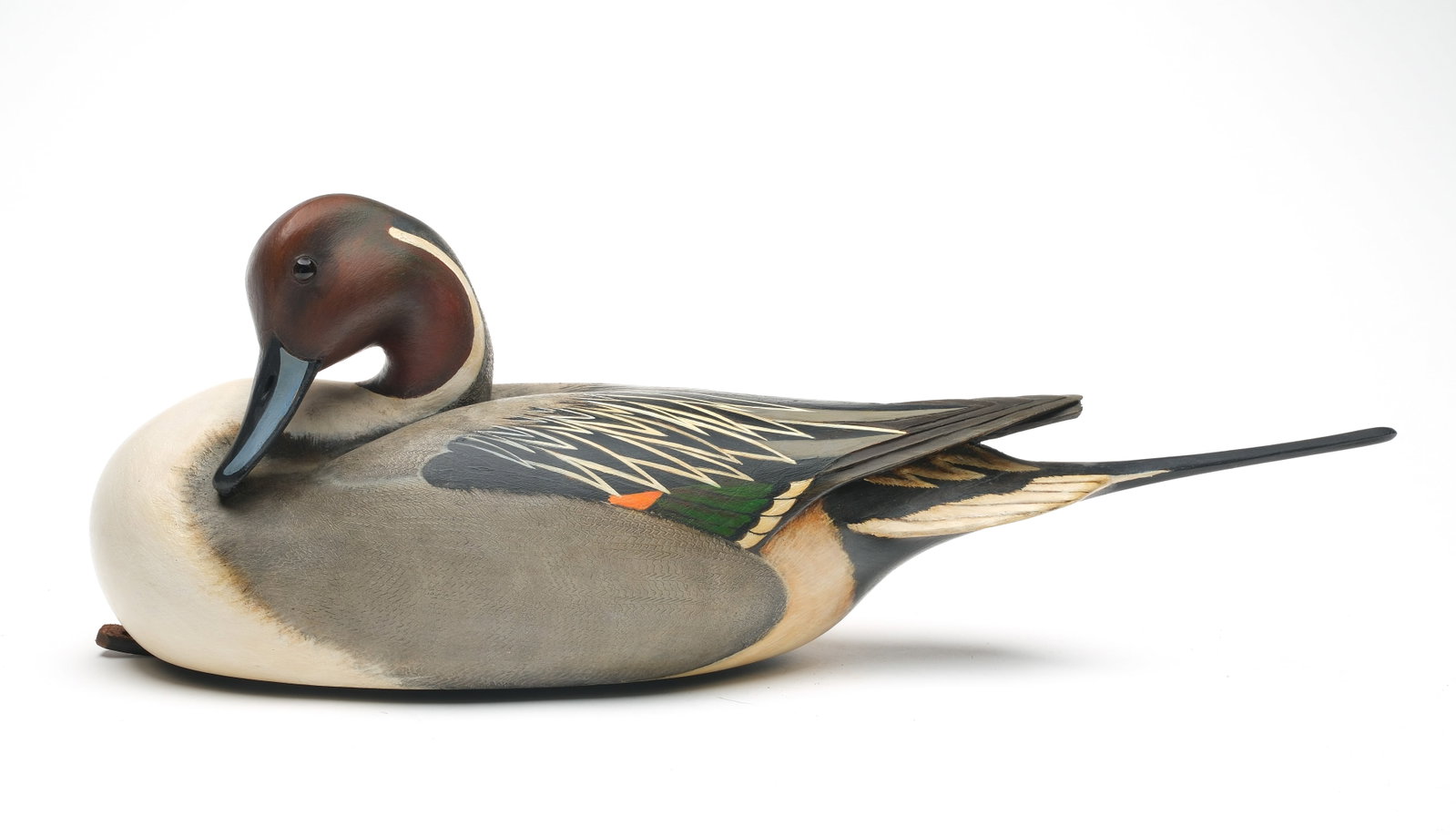 William Gibian (b.1946), Onancock, Virginia.: Preening pintail. Hollow carved with raised, crossed wingtips and head twisted in breast preening pose. Gibian carved in underside. Maker's business card is signed and dated 5/15. Measures 20" long.