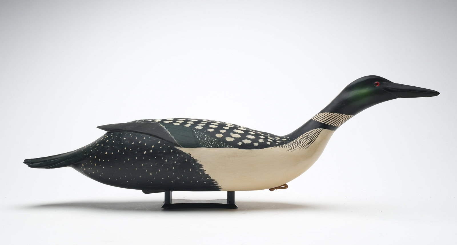 Bob White (b. 1939) Tullytown, Pennsylvania.: Rare swimming loon in summer plumage. Hollow carved with raised wingtips. Head is slightly turned. Signed and dated 1994 on underside. Measures 26" long.