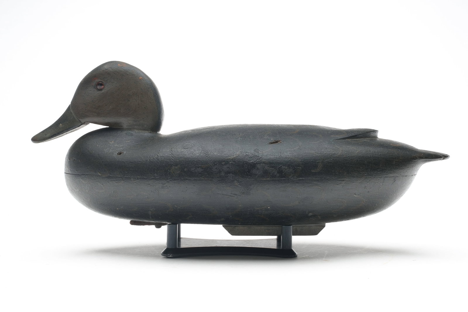 John H. Baker (1916-2004), Bristol, Pennsylvania.: Early style black duck. Hollow carved with relief wingtip carving and tucked head. Maker's name and town stamped in lead weight. Measures 15.25" long. Provenance: John Decesare collection.