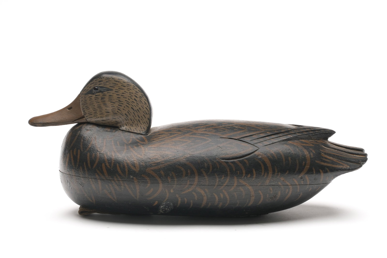 Thomas Fitzpatrick (1887-1958) Delanco, New Jersey.: Tucked head black duck. Hollow carved with raised V wingtip carving and relief tail feather carving. From the Appleton rig, Bristol Pennsylvania. Copper rig tag on underside. Measures 15" long.