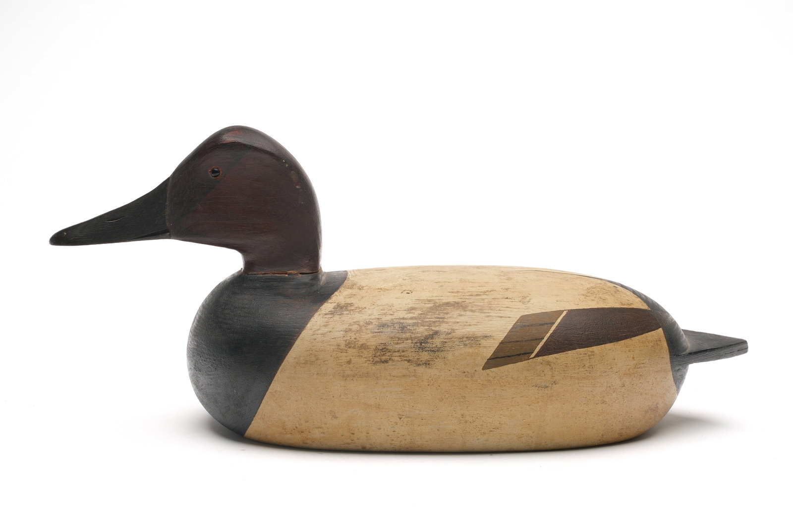 John Dawson (1889-1959), Duck Island, New Jersey.: Canvasback. Hollow carved with raised neck seat. Never rigged or weighted. "JD" stamped in underside. Writing in ink about the history of this decoy written on underside. Measures 16" long.