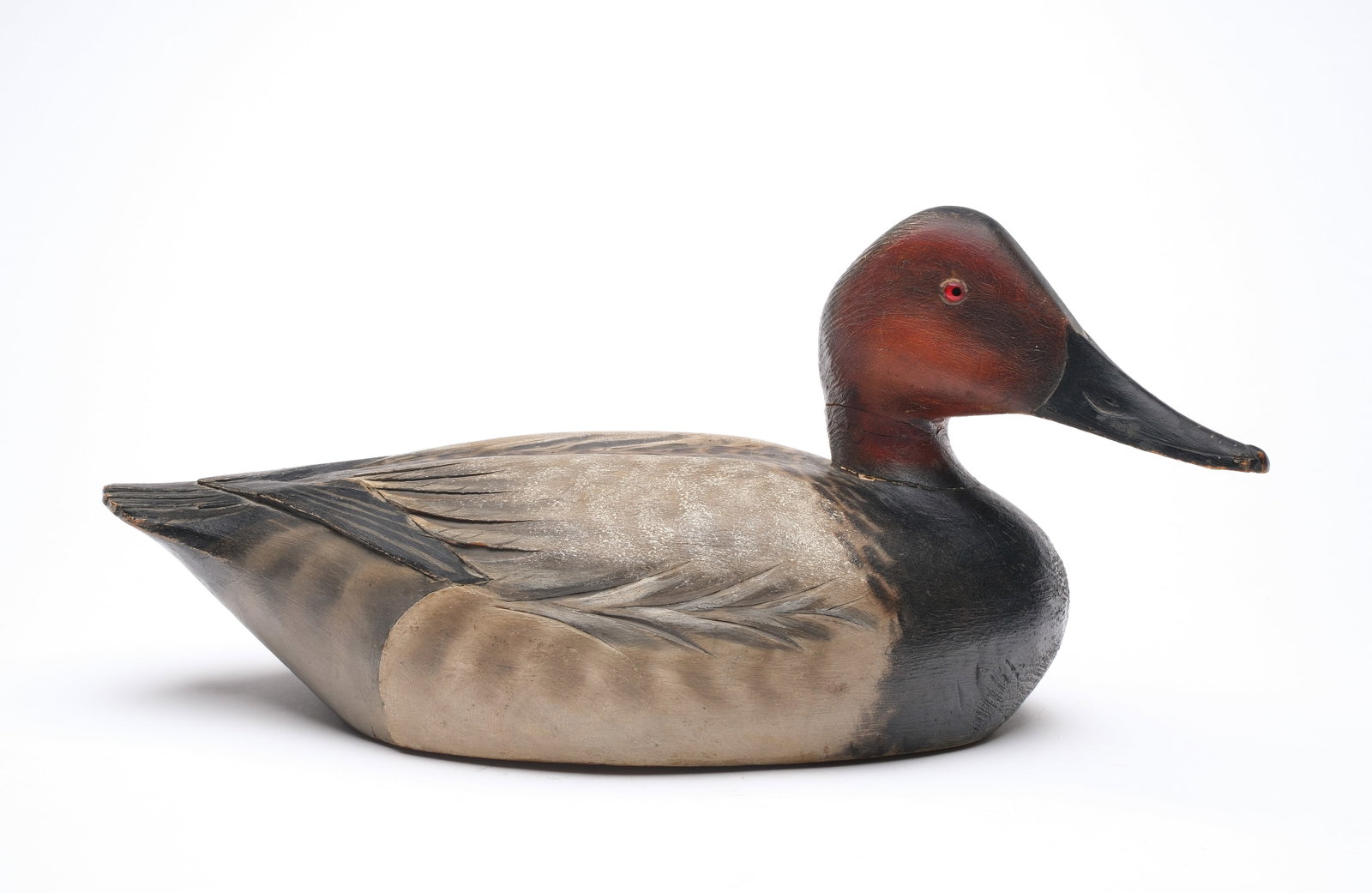 A. Elmer Crowell (1862-1952), East Harwich, Massachusetts.: Canvasback with deep relief wing and tail feather carving. Maker's rectangle stamp on underside. Also signed and dated 1937 by the maker. George Thompson collection ink stamp on underside. Measures 15