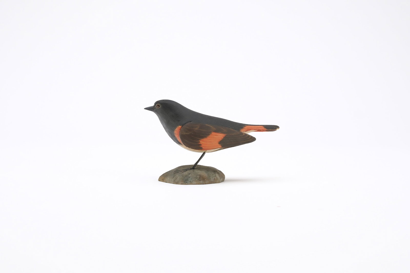 Jess Blackstone (1909-1988), Concord, New Hampshire.: Miniature redstart. Relief wing carving with dropped wingtips and feather rasping. Identified and with maker's paper label on underside. Measures 3.75" long. Provenance: Joseph Ellis collect
