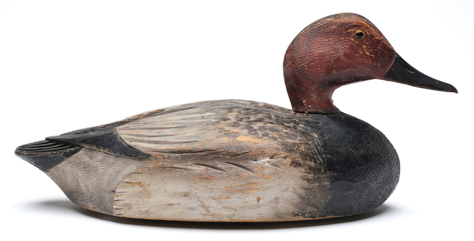 A. Elmer Crowell (1862-1952), East Harwich, Massachusetts.: Early working canvasback. Deep relief wing and tail feather carving. Mackey collection ink stamp on underside. "MMO" branded three times on underside. Measures 16" long. PROVENANCE: Don Leonard 