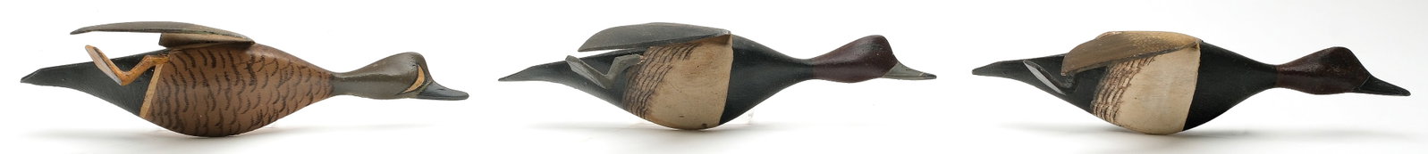 Roy Conklin (1909-1967), Alexandria Bay, New York.: Three miniature flying ducks. A redhead, canvasback, and bluewing teal with applied wings and feet. Maker's ink stamp on backs. Measure 8.5" long. PROVENANCE: John Decesare collection.