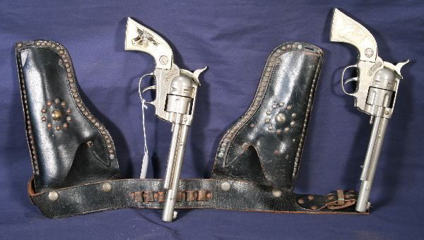 NETTE - HUBLEY Cowboy Cap Pistols with Holster: Nice set, circa 1950, 1 has black steer handles, white gun has very small chip in 1 grip corner, both nickel finish, some wear to holster belt, o/w C7+