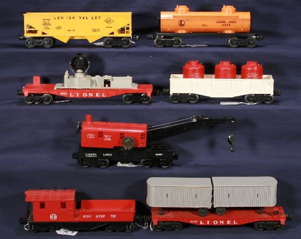 NETTE - 7 Late LIONEL Freight Cars:: 6465 Orange Tank Car; 6440 Flat w/Gray Vans; 6130 Work Caboose, unpainted cab version; 6176 LV Hopper; Unusual 6560 Crane w/1 fixed coupler; 6822 Searchlight Car, missing figure; Scarce unlettered whi