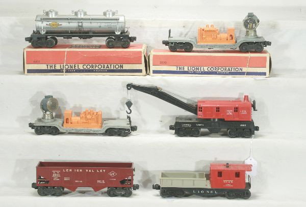 NETTE - 6 LIONEL Freight Cars:: 6560 Crane; 6110-100 Work Caboose; 6456 LV Hopper; 3620 Searchlight Car; 3520 Searchlight, missing brakewheel handle, ob; 6415 Tank car, small nick in catwalk, ob, dusty, o/w C6 or better