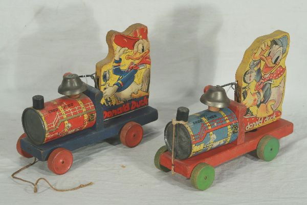 NETTE - 2 Early FISHER PRICE Donald Duck Toy Train: Two black Label Pre War variations of the 450 Choo Choo. 8 1/2" L each, 1 has string, both show play wear, but not too badly, C6-7 ish.